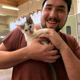 An adopter holds a kitten