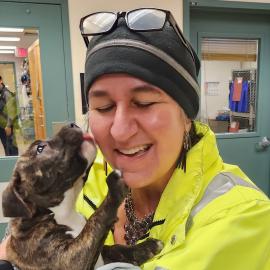 Emergency Management Analyst Alice Busch takes a break from coordinating shelter operations to snuggle a puppy