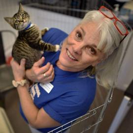 Woman holding a kitten near her shoulder