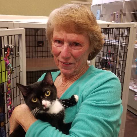 Woman standing holding a cat to her chest