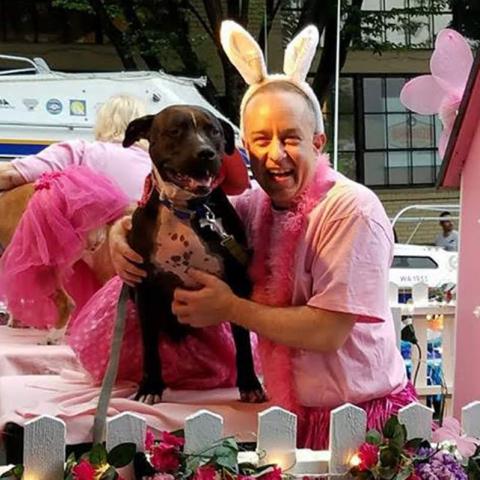 Jason the volunteer poses on the Pitties in Pink float with his dog, Zev.