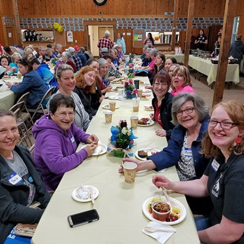 Volunteers sitting at a table looking towards the camera and smiling
